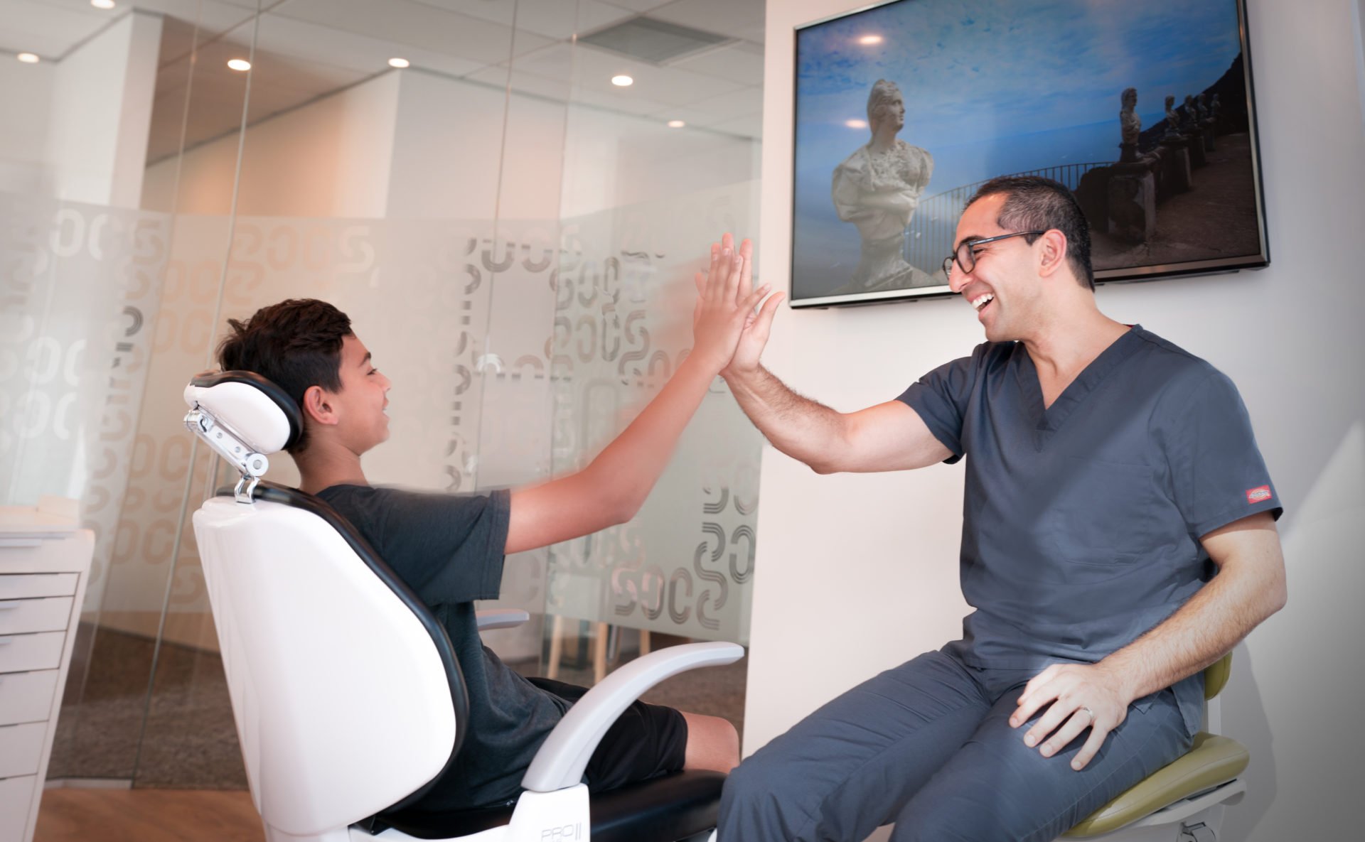 Orthodontist and child high five